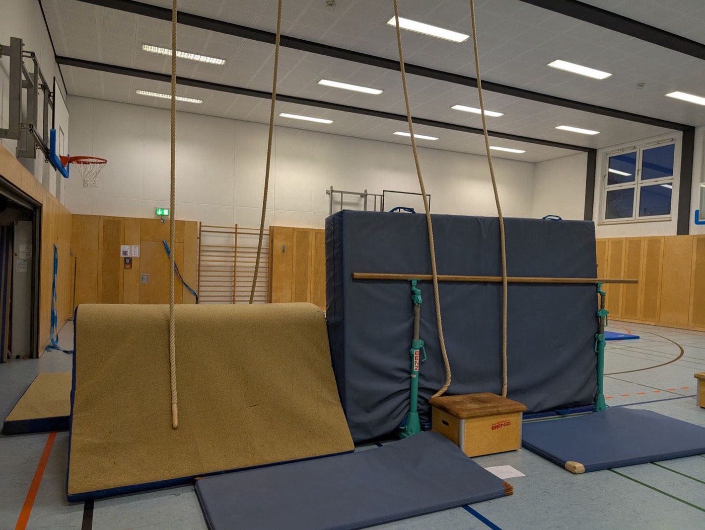 Kletterwand aus Matten, Taue und ein kleiner Kasten als Aufstiegshilfe.